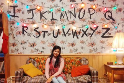 Girl sitting on couch of Stranger Things Living Room Replica